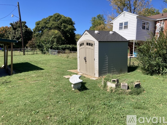A shed sits in a grassy yard.