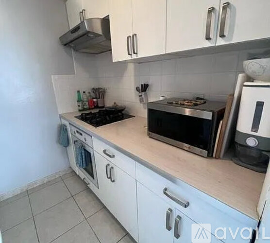 A kitchen with white cabinets and a wooden countertop.
