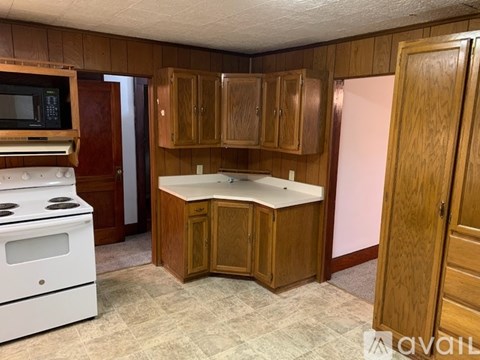 A kitchen with wooden cabinets and a white stove.