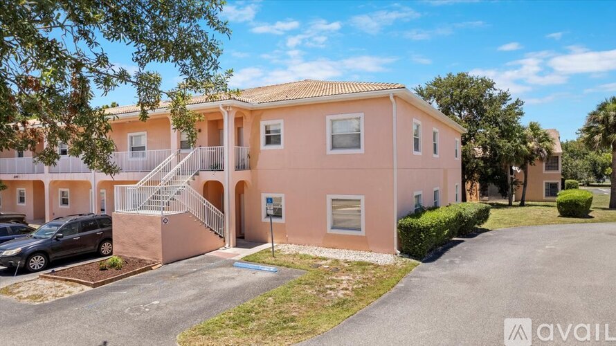 A pink house with a car parked in front and a blue sign with the text "AVAIL" on it.