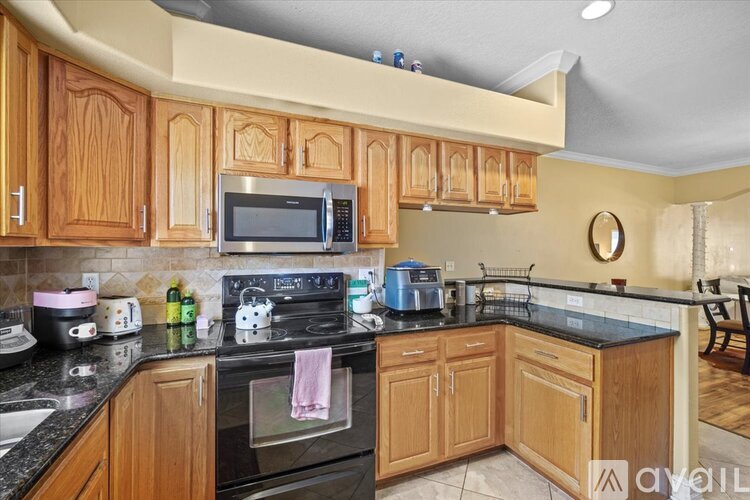 A kitchen with wooden cabinets and black appliances.