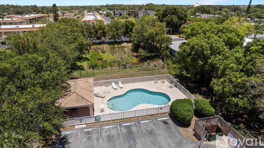 A swimming pool surrounded by trees and a fence.