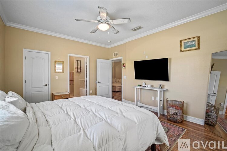 A bedroom with a large bed and a flat screen TV mounted on the wall.
