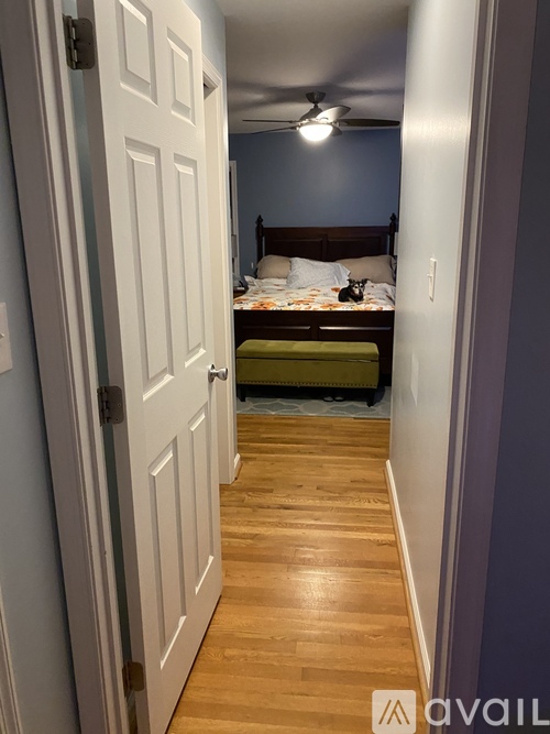 A bedroom with a bed, a green chair, and a white door.