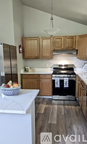 A kitchen with wooden cabinets and a black stove top oven.