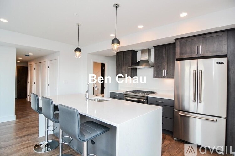 A modern kitchen with a white island and stainless steel appliances.