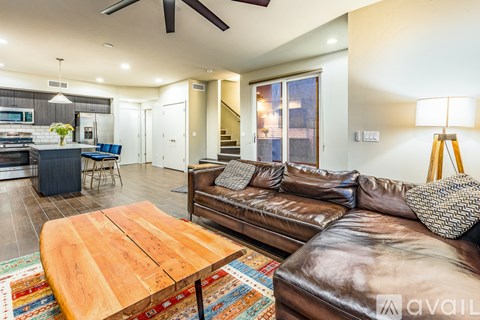 A living room with a brown leather couch and a wooden coffee table.
