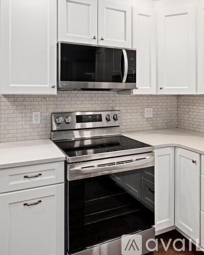 A kitchen with white cabinets and a stainless steel oven.