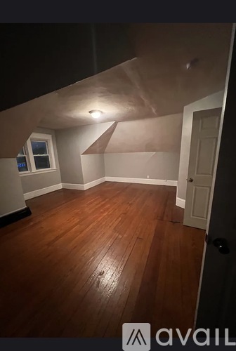A room with wooden flooring and a window.