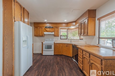 A kitchen with wooden cabinets and a white refrigerator.