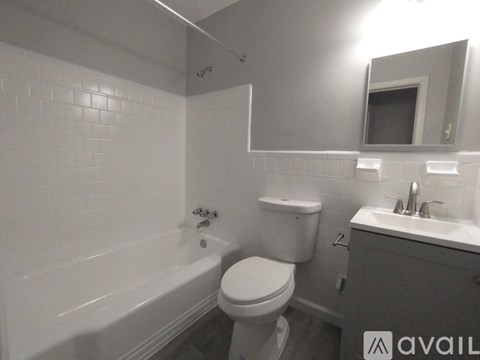 A bathroom with a toilet, sink, and bathtub.