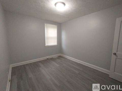 A room with a window and wooden flooring.