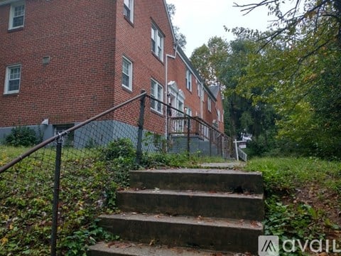A red brick building with a metal fence and stairs leading up to it.