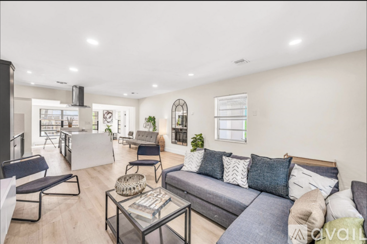 A living room with a grey couch and a glass coffee table.