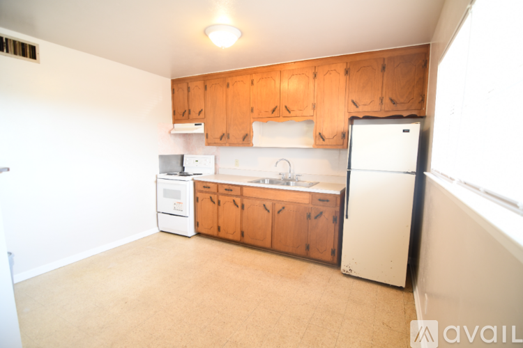 A kitchen with wooden cabinets and white appliances.