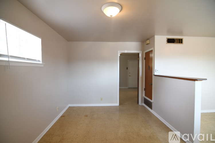 A room with a window and a door leading to another room.