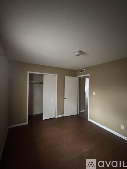 A room with a brown floor and white walls.