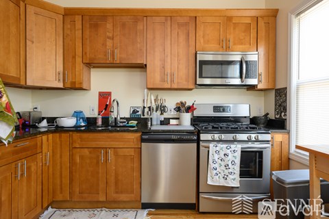 A kitchen with wooden cabinets and a stainless steel stove.