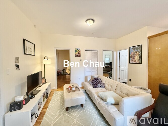 A living room with a white couch and a television.
