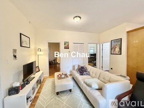 A living room with a white couch and a television.