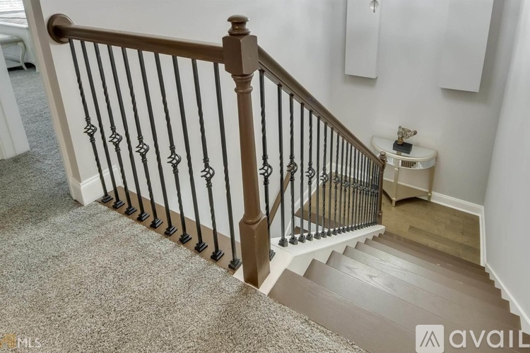 A staircase with a metal railing and wooden handrail.