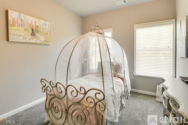 A bedroom with a canopy bed and a painting on the wall.