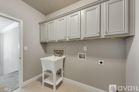 A kitchen with white cabinets and a white island.