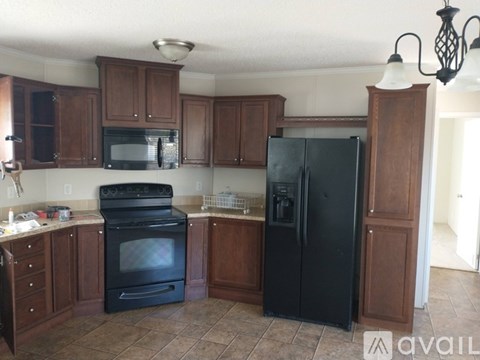 A kitchen with black appliances and wooden cabinets.