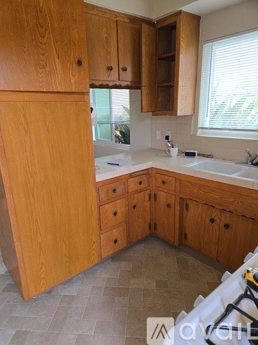 A kitchen with wooden cabinets and a tile floor.