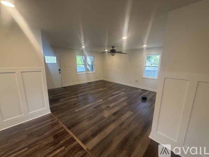 A room with wooden flooring and white walls.