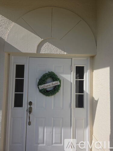 A white door with a wreath on it.