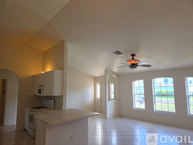 A spacious kitchen with a fan on the ceiling.