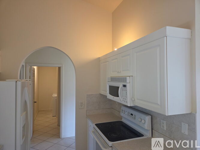 A kitchen with white appliances and cabinets.
