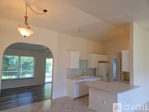 A kitchen with white appliances and cabinets is available for rent.