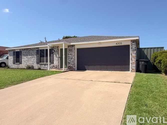 A two-car garage with a stone facade and a black roller shutter door.