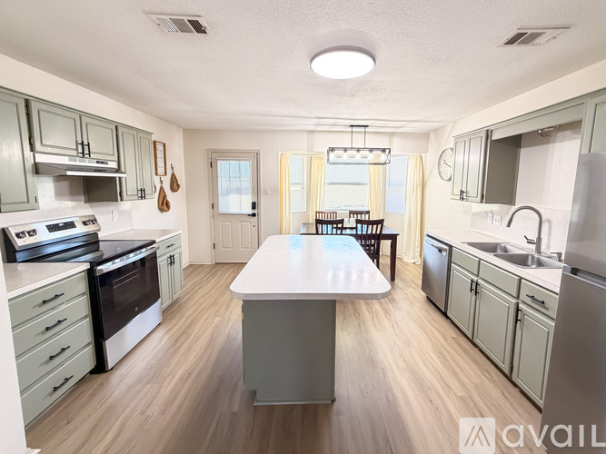 A kitchen with a table in the middle of the room.