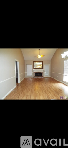 A room with wooden floors and a television mounted on the wall.