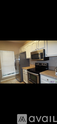 A kitchen with white cabinets and a black stove top.