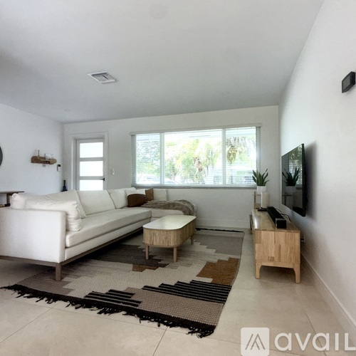 A living room with a white couch and a wooden coffee table.