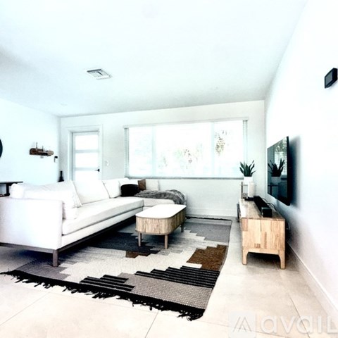 A living room with a white couch and a wooden coffee table.