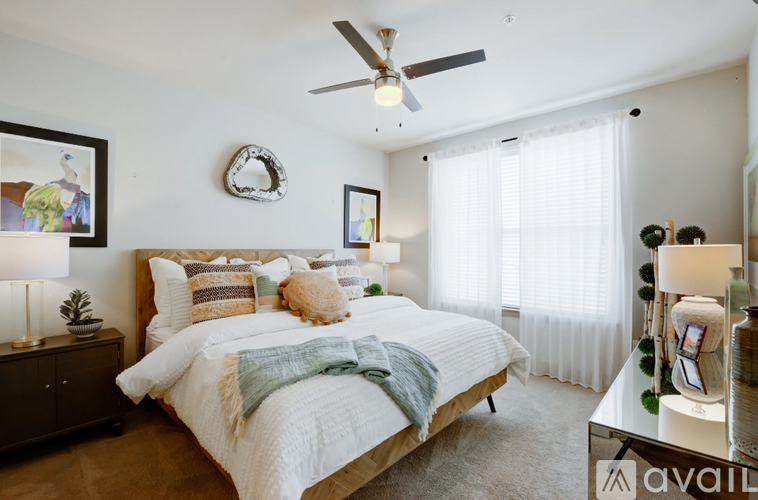 A bedroom with a large bed and a ceiling fan.