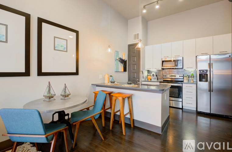 A kitchen with a table and chairs in front of it.
