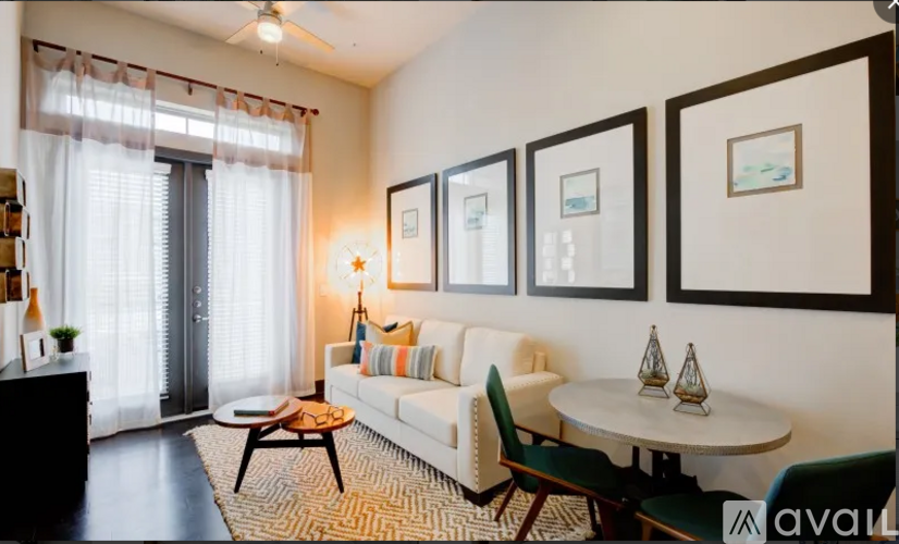 A living room with a white sofa, a coffee table, and a dining table with chairs.