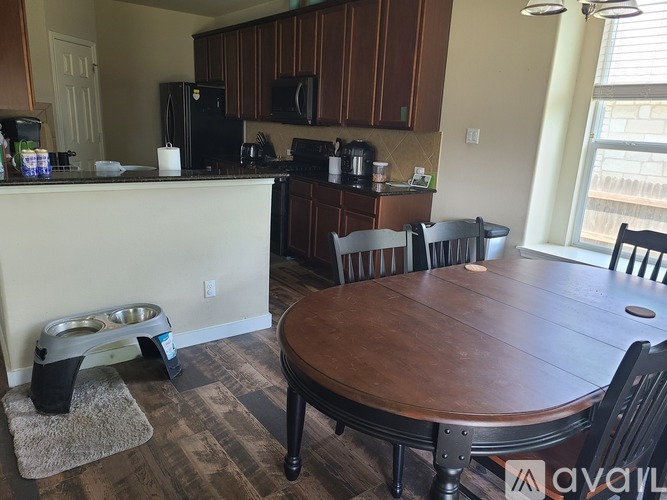 A kitchen with a table and chairs.