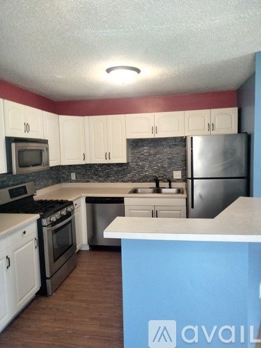 A kitchen with white cabinets and a blue counter.