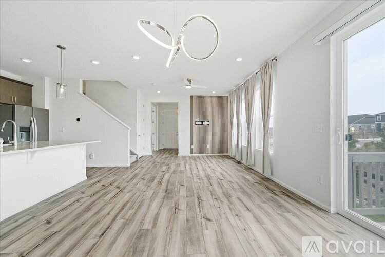 A spacious room with wooden flooring and a large window.
