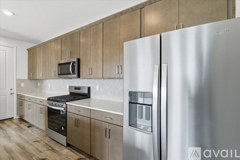 A kitchen with a Whirlpool refrigerator and stainless steel appliances.