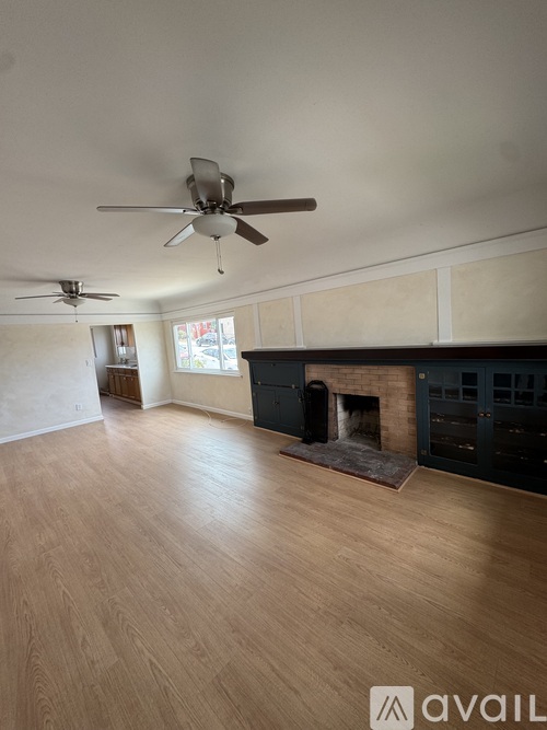 A room with a fireplace and a ceiling fan.