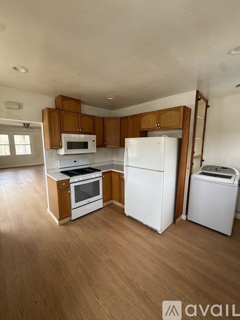 A kitchen with wooden cabinets and white appliances.