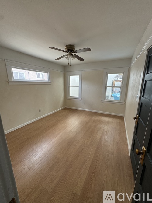 A room with wooden flooring and a ceiling fan.